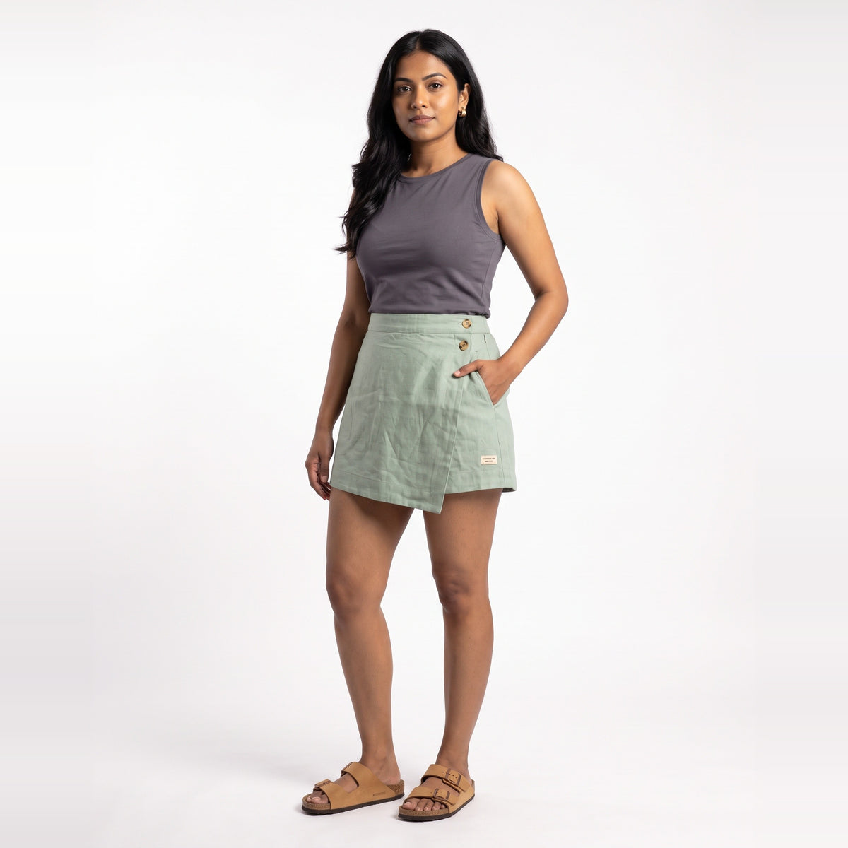 Sage linen skort with pockets, front view on model