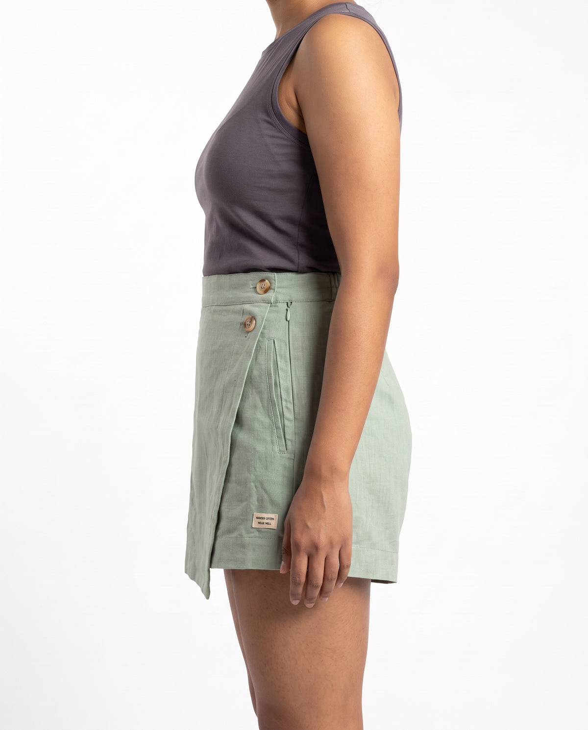 Sage linen skort with pockets, right side view showing buttons and wrap flap