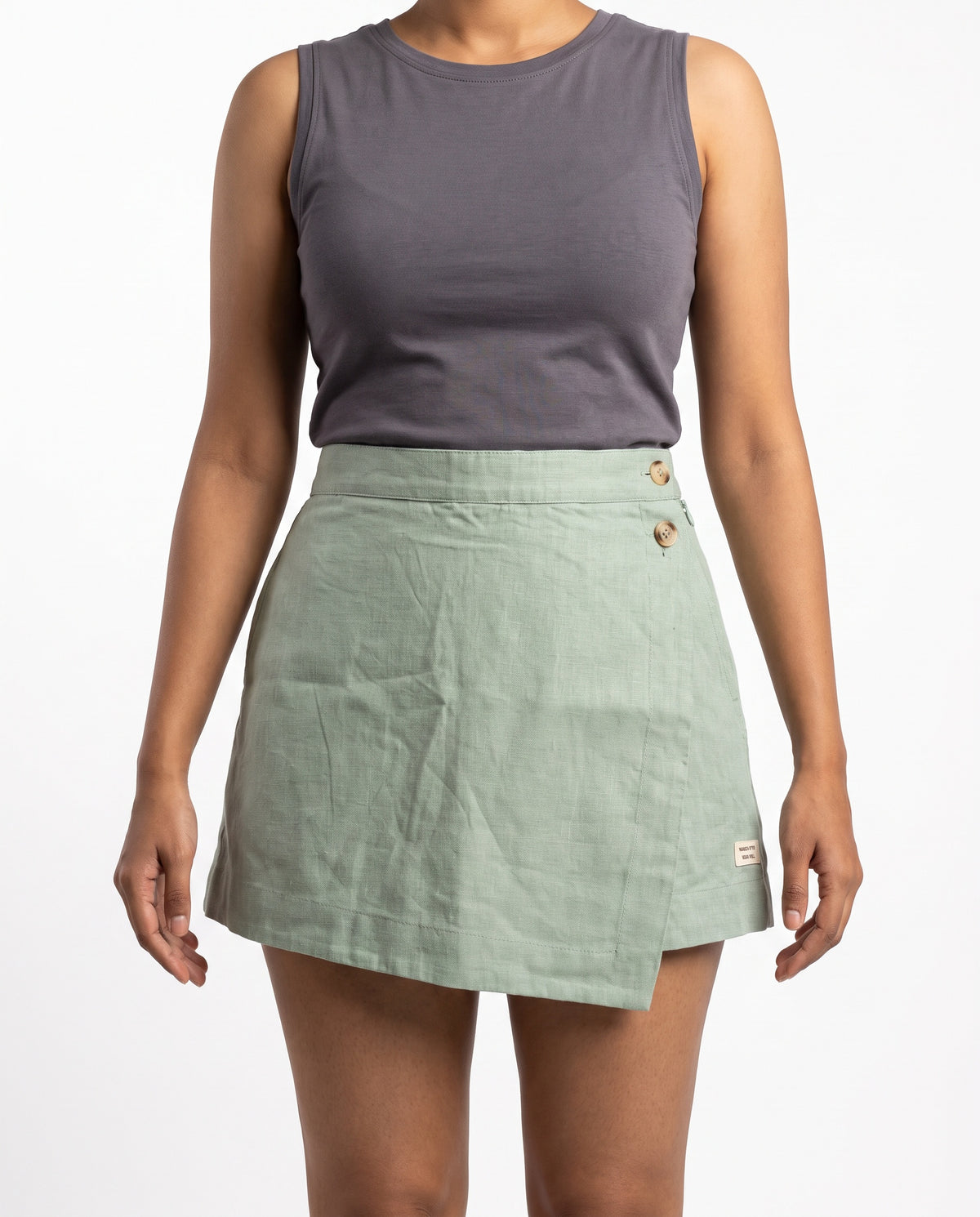 Sage linen skort with pockets, front close-up on model