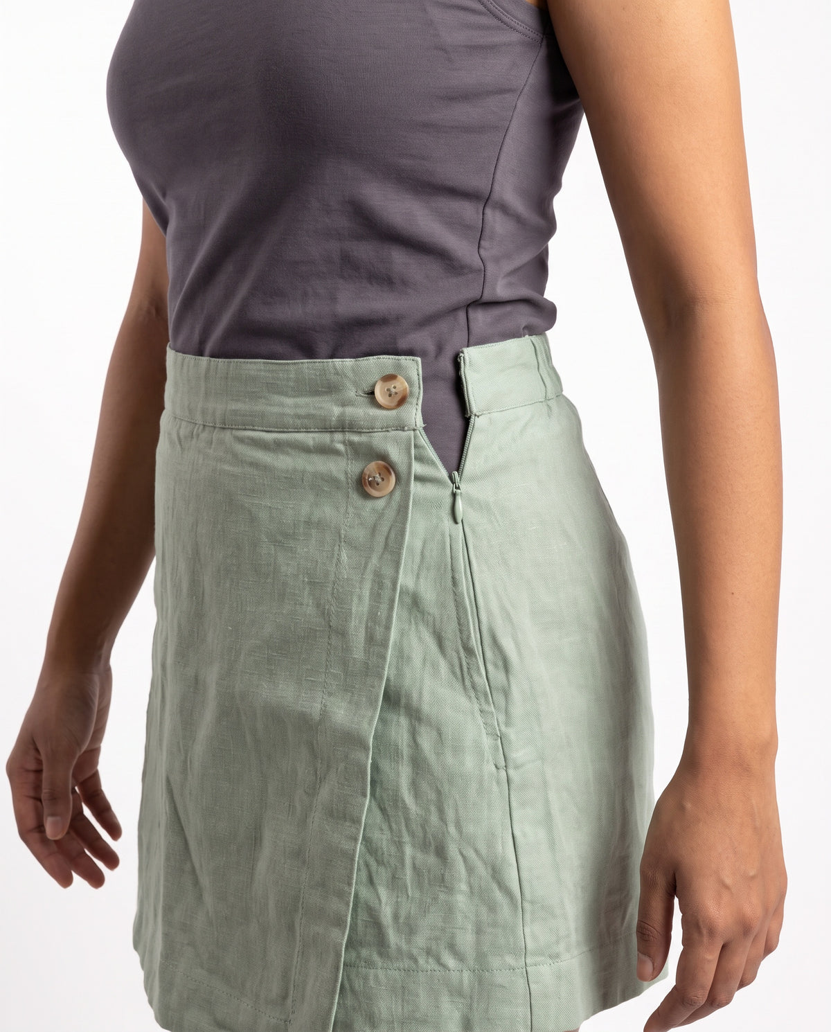 Sage linen skort with pockets, close-up of the hidden side zip
